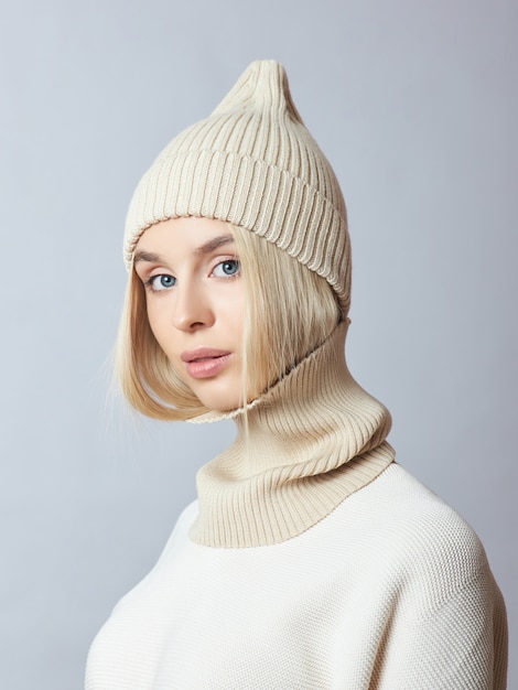 Donna in abiti primaverili, sciarpa snood, cappello e guanti. la ragazza è bionda con gli occhi azzurri.