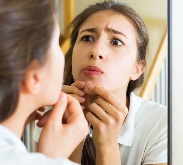 Woman squeezing spot with fingers