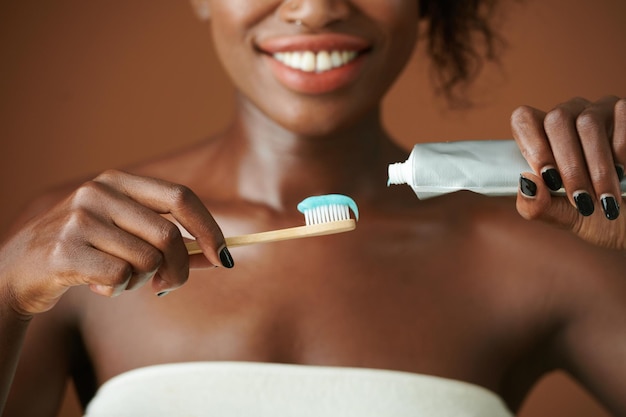 Woman Squeezing Toothpaste on Brush