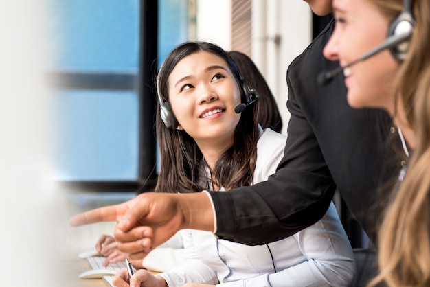 Woman staff being trained by supervisor in call center