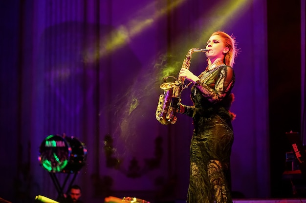 Foto donna sul palco che suona il sassofono, concerto dal vivo