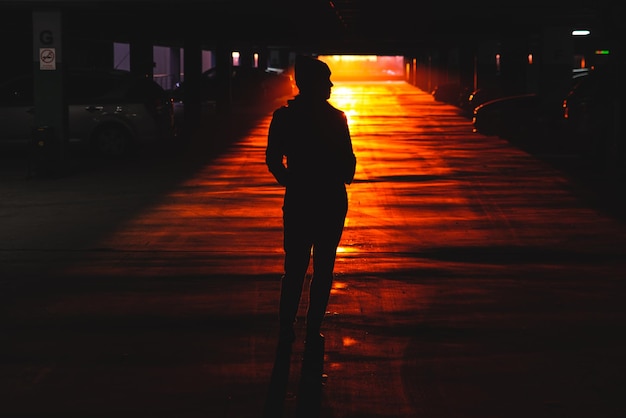 Woman stand at car parking look on orange sunset