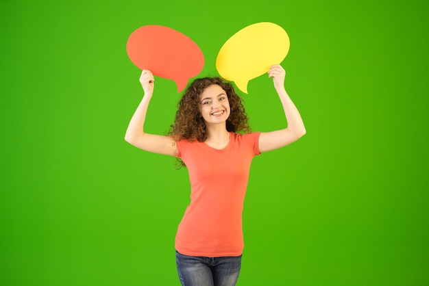 The woman stand with a dialog signs on the green background