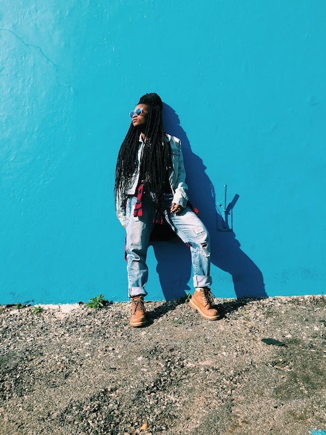 Woman standing against blue wall