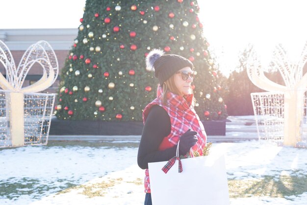 写真 冬のクリスマスツリーに立っている女性