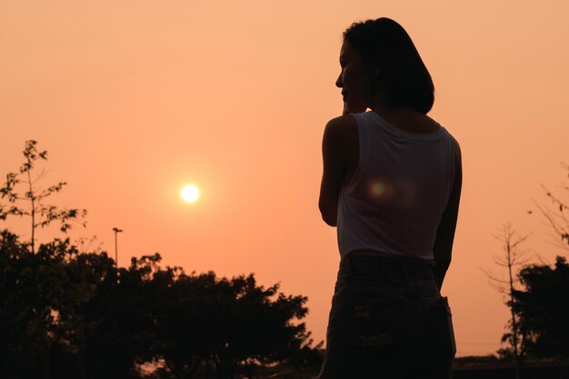 Woman standing against clear sky during sunset