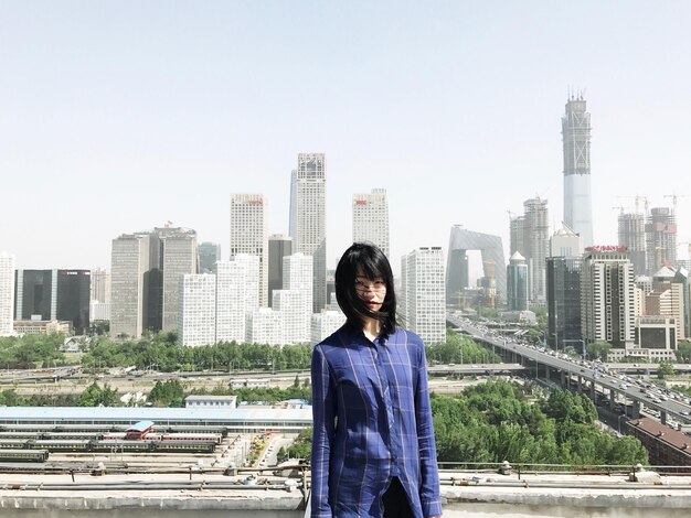 사진 은 하늘에 대한 현대 도시 풍경에 맞춰 서 있는 여성