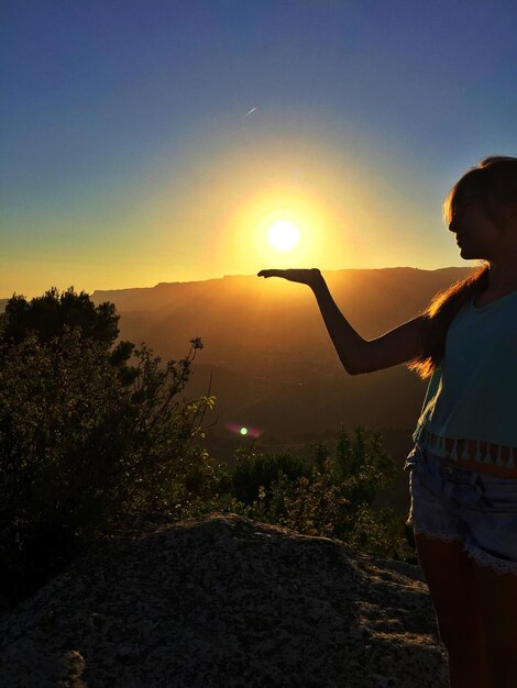 Photo woman standing against mountain during sunset