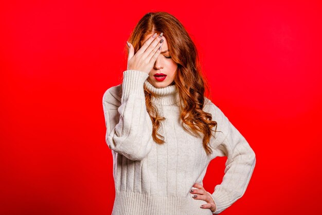 Woman standing against red background