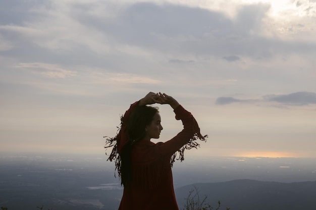 夕暮れの空に向かって立っている女性