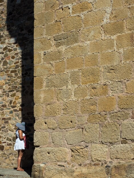 Photo woman standing against stone wall