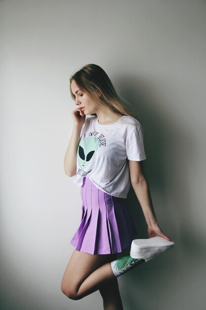 Woman standing against wall at home