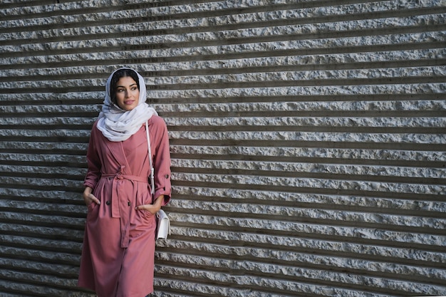 Foto donna in piedi contro il muro