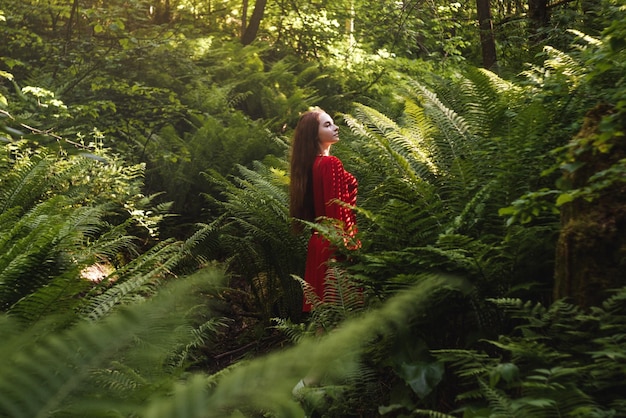 森の植物の中に立っている女性