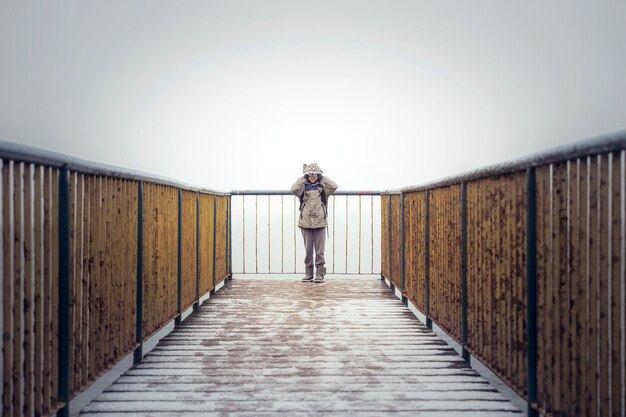 写真 冬の晴れた空の向こうの観測点に立っている女性