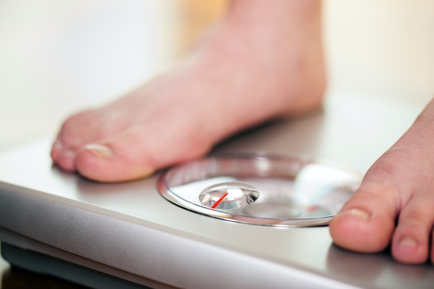 Woman standing on bathroom scale