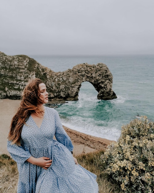 Foto donna in piedi sulla spiaggia contro un cielo limpido