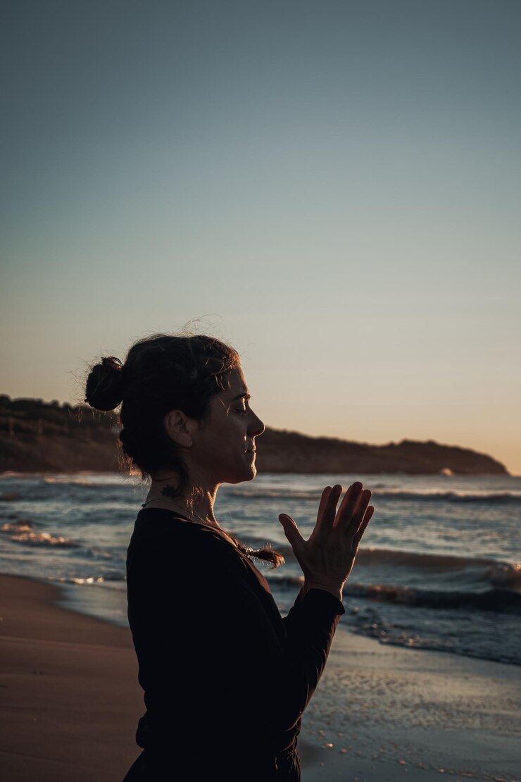 Photo woman standing at beach against sky during sunrise