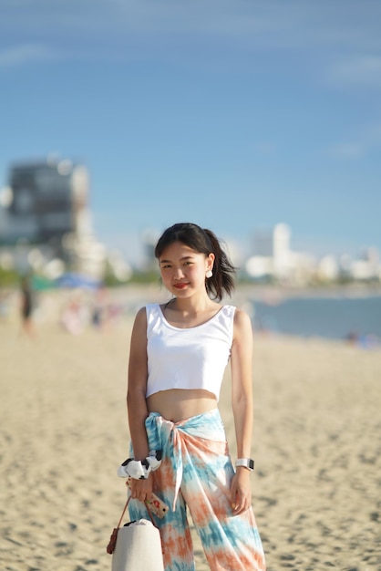 空に向かってビーチに立っている女性
