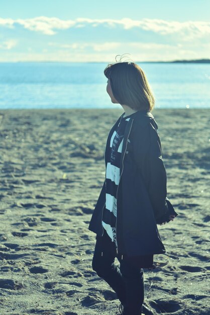 Photo woman standing on beach against sky