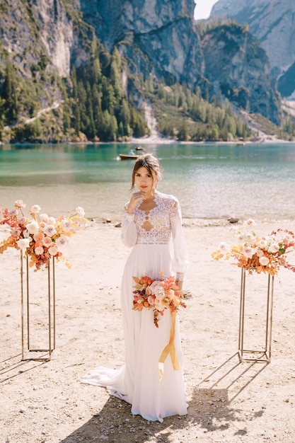 Foto donna in piedi sulla spiaggia vicino al mare