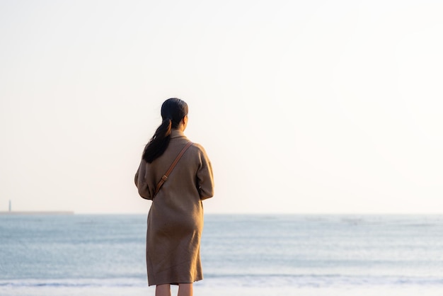 Woman standing on beach watching sunset