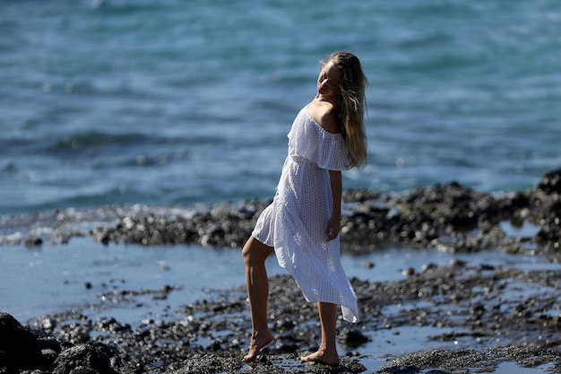 Foto donna in piedi sulla spiaggia