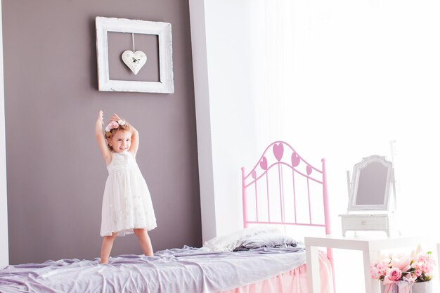 Photo woman standing on bed at home