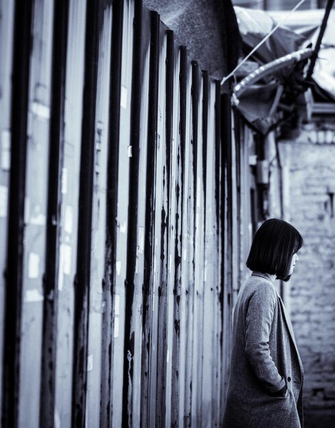 Photo woman standing beside wall