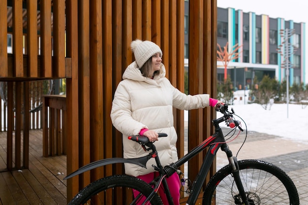 建物の前で自転車の隣に立っている女性