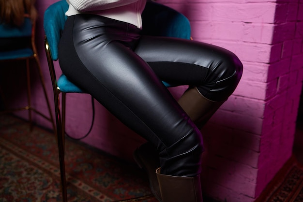 A woman standing in black tights and boots