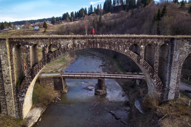 Photo woman standing on brick bridge in dragobrat landscape photo