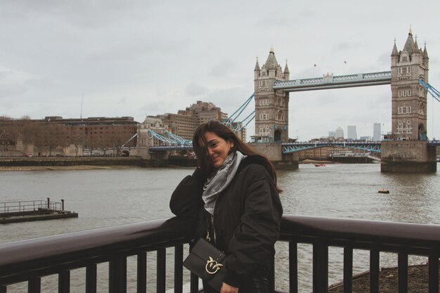 Foto donna in piedi sul ponte sul fiume