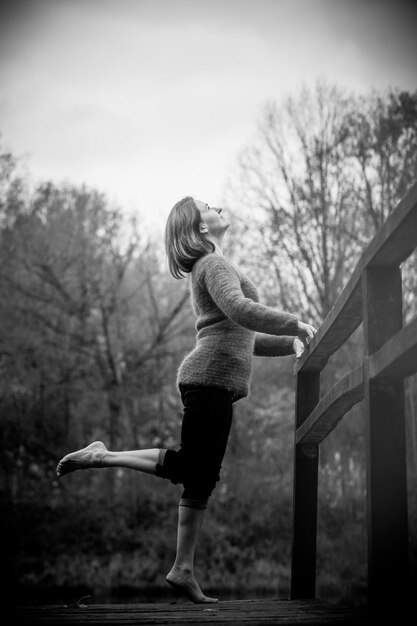 Photo woman standing by bare tree against sky