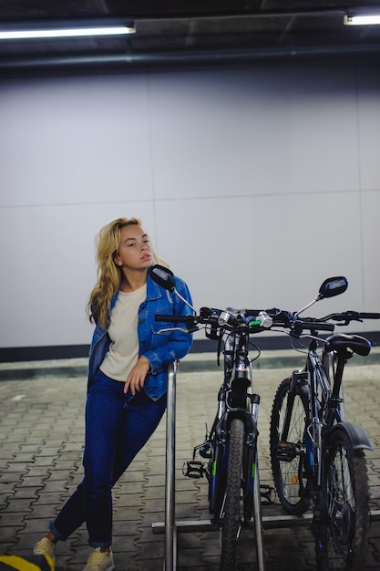 Foto donna in piedi accanto alla bicicletta nel seminterrato