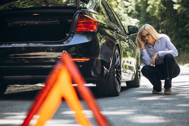 Foto donna in piedi vicino all'auto a causa di un guasto