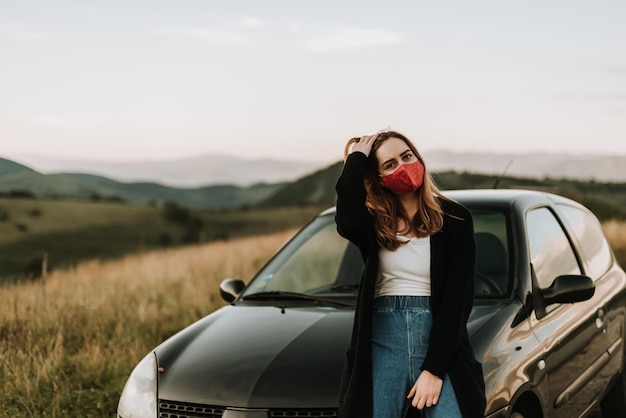 空の向こうのフィールドで車に乗って立っている女性