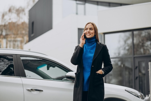 通りの外で彼女の車のそばに立っている女性