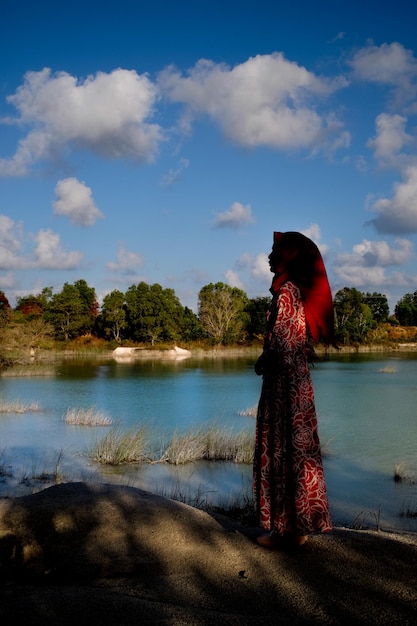 Woman standing by lake against sky