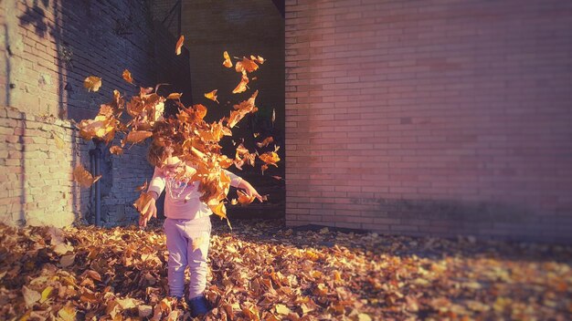 Woman standing by leaves during autumn