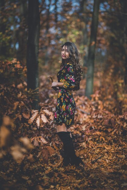 Photo woman standing by leaves on tree in forest