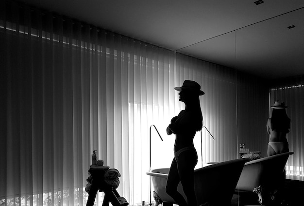 Woman standing by mirror in room