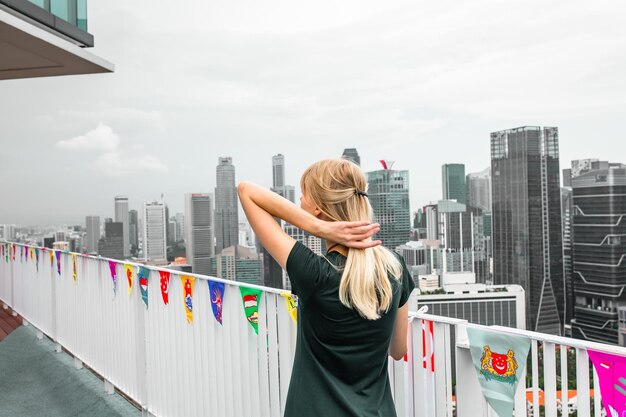 Photo woman standing by modern buildings against sky in city