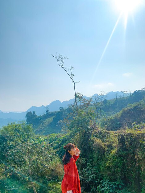 Photo woman standing by plants against sky