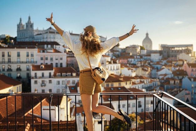 Woman standing by railing against buildings in city