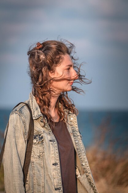 Foto donna in piedi sul mare contro il cielo