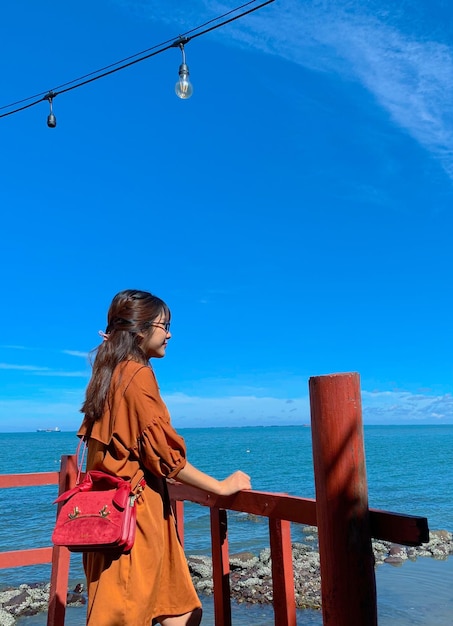 Foto donna in piedi vicino al mare contro il cielo