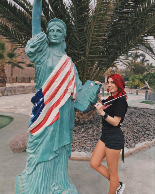 Foto donna in piedi vicino alla statua della libertà