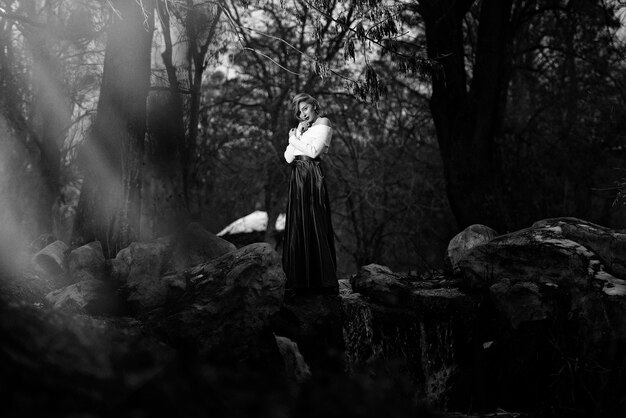 Photo woman standing by tree trunk in forest