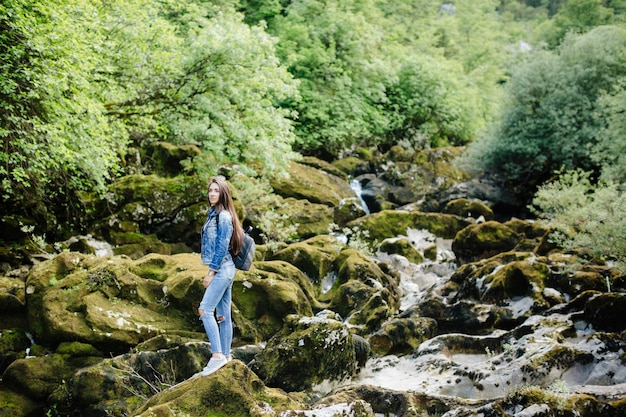 Woman standing by waterfall in forest